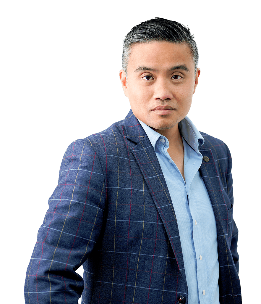 Three-quarter portrait of Professor Paul Lee leaning forward in a blue plaid blazer